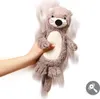 A hand holding a plush otter toy against a white background. Náhľad obrázku produktu