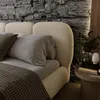 A close-up view of a modern bed with a textured headboard and bedding. Produktbild-Vorschau
