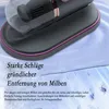 A close-up marketing shot of a handheld vacuum cleaner on a blue fabric surface. Produktbild-Vorschau