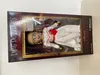A doll in its packaging, displayed on a white and light gray surface. Náhled obrázku produktu