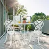 A white metal bistro set with a rose pattern is placed on a wooden deck on a balcony. Náhľad obrázku produktu