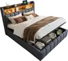 A bed with its storage compartment open, showing stored items. Produktbild-Vorschau
