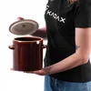 A person is holding a brown ceramic pot with a lid. Voir les images du produit