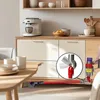 A vacuum cleaner accessory is shown attached to a Dyson vacuum cleaner, cleaning under a cabinet. Podgląd zdjęcia produktu