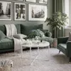A living room scene with a green sofa, coffee table, and plants. Produktbild-Vorschau