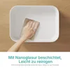 A hand is cleaning a white basin with a sponge. Voir les images du produit