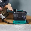 A person is using a portable carpet cleaner on a rug. Produktbild-Vorschau