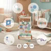 A wooden baby walker with various interactive toys is shown in a nursery setting, surrounded by other baby items. Produktbild-Vorschau