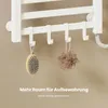 A close-up of a white towel warmer with hooks, displaying a brush and a loofah hanging from it. Text overlays provide marketing information. Anteprima dell’immagine prodotto