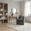 A cozy living room corner with a bookshelf, desk, armchair, and rug. Produktbild-Vorschau