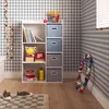 A child's room with a white shelving unit filled with toys and books, against a blue and white checkered wallpaper. Produktbild-Vorschau