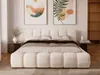 A bedroom scene with a bed as the focal point, decorated with artwork and a side table. Produktbild-Vorschau
