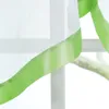 A close-up view of a sheer white curtain with a green satin ribbon trim. Produktbild-Vorschau