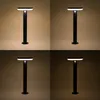 A collage of four images showing a black solar-powered outdoor lamp with a light at the top, displayed against different colored backgrounds. Produktbild-Vorschau