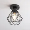 A black geometric pendant light fixture with a visible Edison-style bulb is mounted on a white ceiling. Produktbild-Vorschau