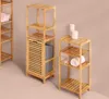Three bamboo shelving units are displayed against a plain background. The largest unit on the left has a built-in laundry basket. The middle unit is tall and narrow with shelves and a laundry basket. The smallest unit on the right has three shelves and is  Produktbild-Vorschau
