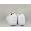 The back view of two white Adidas sneakers on a textured gray background. Produktbild-Vorschau