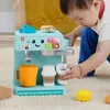 A baby is playing with a toy coffee maker. Náhľad obrázku produktu