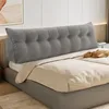 A grey tufted wedge pillow is placed on a bed behind the pillows. Produktbild-Vorschau