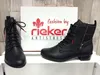 A pair of black Rieker ankle boots are displayed with their box. Voir les images du produit