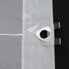 A close-up view of a white sheer curtain with a silver triangular pattern and a silver eyelet attached to it, with a black background. Produktbild-Vorschau