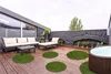 Raumbild. Mehrere Kunstrasen Sansibar in Grün auf einer Dachterrasse ausgelegt. 
 Produktbild-Vorschau
