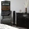 A tower fan next to a patterned armchair, with a dresser in the background. Produktbild-Vorschau