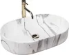 A white oval countertop sink with gray marble-like veining and a gold faucet. Náhľad obrázku produktu