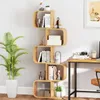 A modern S-shaped bookshelf filled with books and decorative items, placed next to a large potted plant and a desk. Podgląd zdjęcia produktu