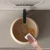 A hand is cleaning a beige ceramic sink with a white cloth. The sink has some orange stains. Anteprima dell’immagine prodotto