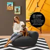 A woman and her dog are relaxing on a beanbag chair in a living room. Náhľad obrázku produktu