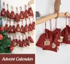 A collage showing two different arrangements of red fabric advent calendar bags with wooden ornaments, one hanging on a clothesline with a Christmas tree, and the other hanging from a wooden branch. Anteprima dell’immagine prodotto
