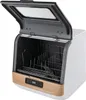 A freestanding countertop dishwasher with its lid open, showing the interior rack system. The product is white with gold accents and a gray lid. Náhled obrázku produktu
