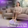 A woman is relaxing on a couch with her feet in a foot bath. Náhľad obrázku produktu