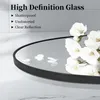 A close-up of a round mirror with white flowers and petals scattered on its surface, set against a light gray and white tiled background. Produktbild-Vorschau