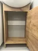 The image shows the interior of a bathroom cabinet with the door open. Voir les images du produit