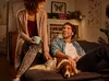 A couple and their dog relaxing on a couch in a living room. Produktbild-Vorschau