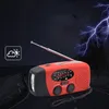 A red and black emergency hand-crank radio with an LED flashlight is shown in a dark, stormy environment with lightning in the background. Podgląd zdjęcia produktu