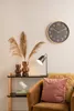 A clock and decorative items are displayed on a shelf next to a chair. Anteprima dell’immagine prodotto