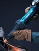 A person wearing work gloves is using a Makita cordless die grinder to grind a metal object, creating sparks. Voir les images du produit
