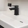 A close-up shot of a modern black faucet installed on a white sink. Produktbild-Vorschau