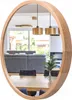 A reflection in a round wooden mirror shows a modern living and dining area with furniture and pendant lights. Náhľad obrázku produktu