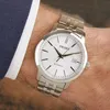 A man's wrist wearing a silver Seiko automatic watch with a white dial. Anteprima dell’immagine prodotto