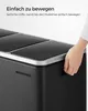 A hand is shown opening the lid of a black multi-compartment trash can. Produktbild-Vorschau