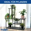 A black metal plant stand with multiple tiers, filled with various potted plants, displayed indoors against a white wall. Podgląd zdjęcia produktu