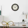 A wall clock is mounted on a white wall above a white desk. Anteprima dell’immagine prodotto