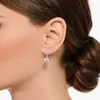 Close-up of a woman's ear wearing a single dangling earring. Produktbild-Vorschau