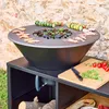 A barbecue grill with food being prepared on it, set up outdoors. Produktbild-Vorschau