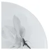 A close-up view of a white porcelain plate with a black and white floral design. Náhľad obrázku produktu