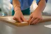 A person's hands are shown applying adhesive strips to the corner of a wooden frame. Anteprima dell’immagine prodotto